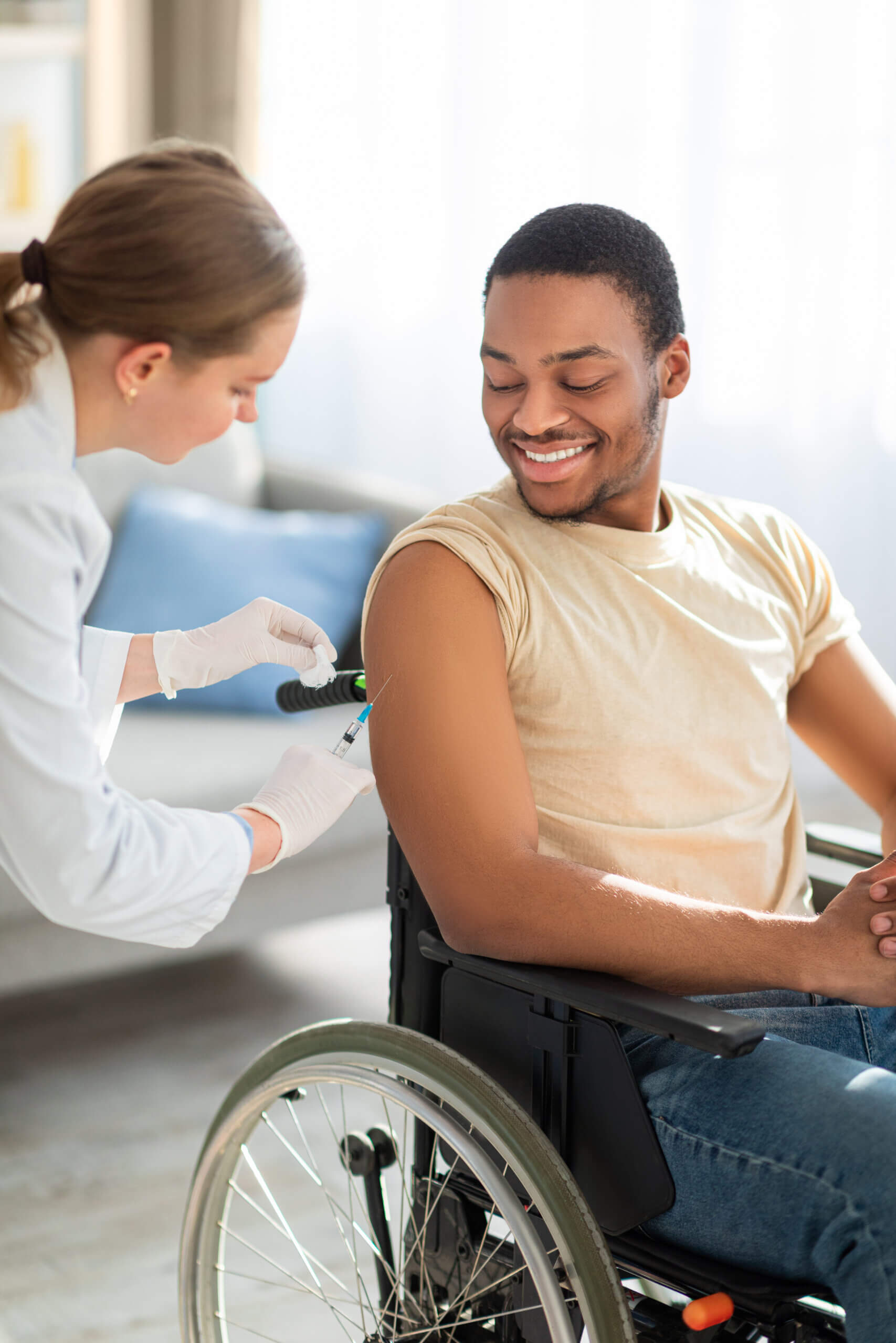 Rx Adherence acknowledging barriers for disabled people at home. Shot given to black male handicapped patient in wheelchair.