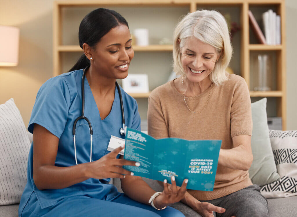 Patient reading point of care patient educational materials given to her by doctor's staff nurse