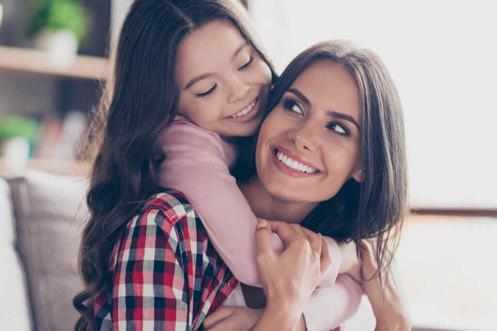 happy hispanic child hugging mother