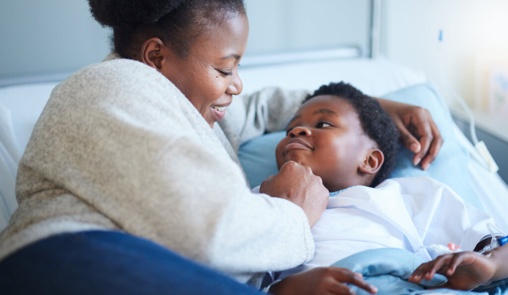 Hospital, bed and black woman with care for child, wellness and hug with a smile in bedroom. Sick, kid and mother embrace with love and gratitude for health, healing and happy for minority organ donation