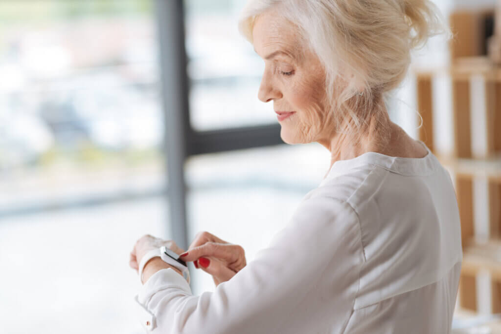 older woman with smart watch in office environment iomt