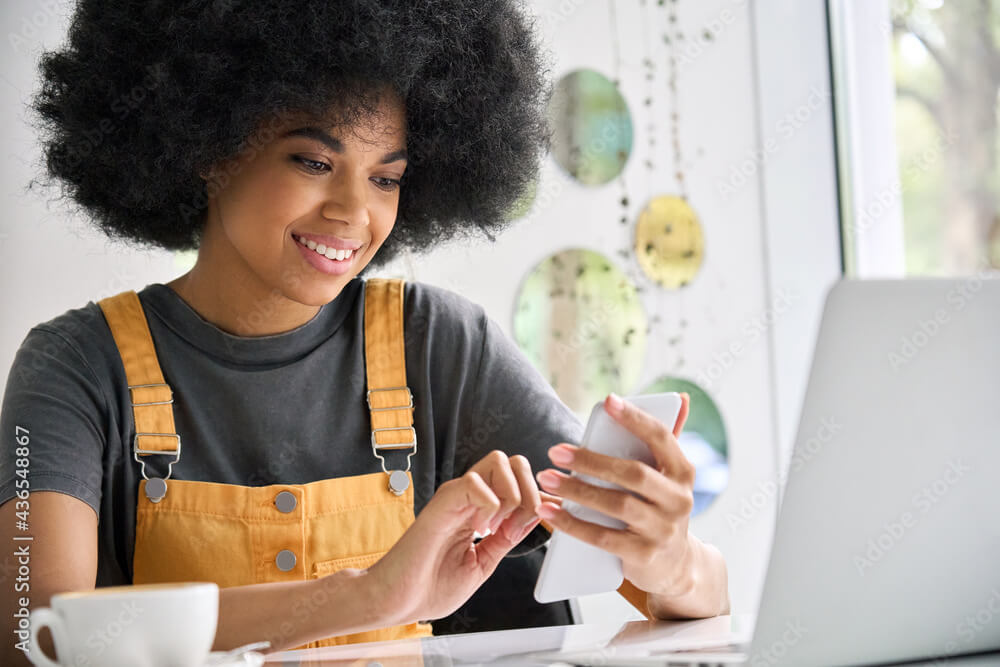 Young Gen Z hipster woman having coffee on the phone