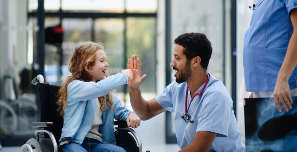 Young multiracial nurse with child patient in wheelchair