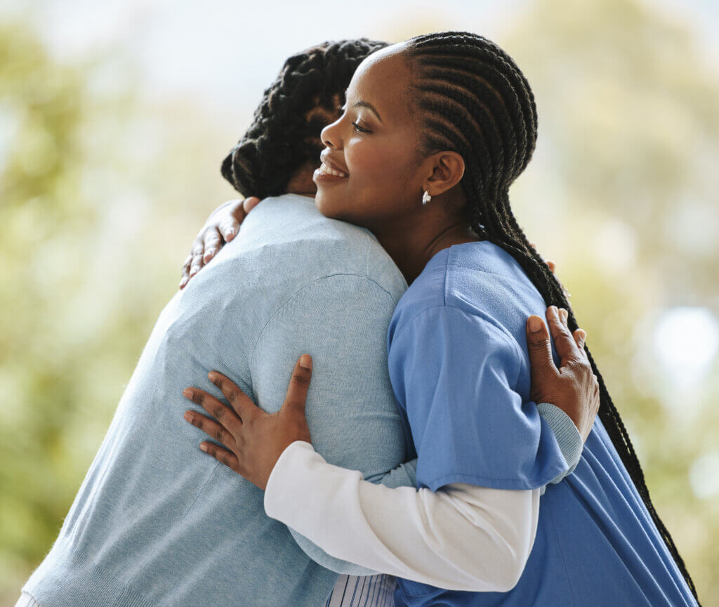 Woman patient, nurse and hug outdoor for support, healthcare and happiness at nursing home. Happy black person, caregiver and together for trust, homecare and help service for health and wellness.