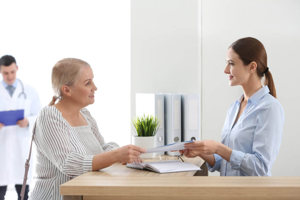 Patient reading treatment and care POC materials before doctor's appointment in hospital for patient education